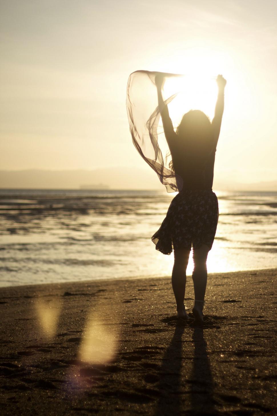 Free Image of Woman Standing on Top of Beach Next to Ocean 