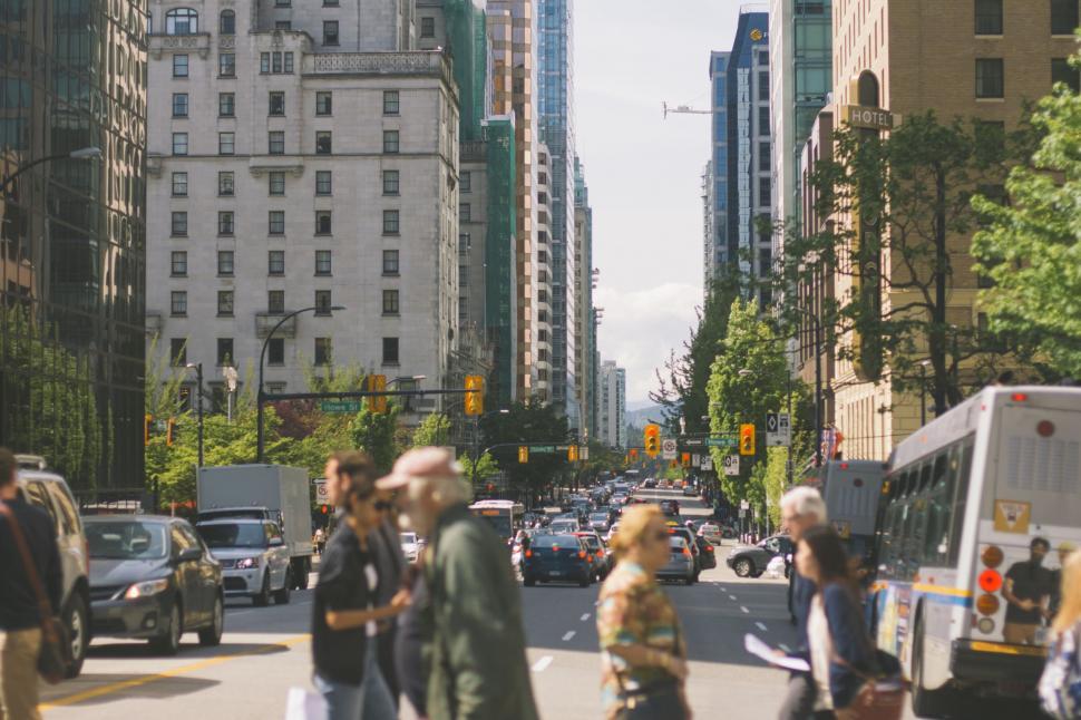 Free Image of Group of People Walking Across Street Next to Tall Buildings 