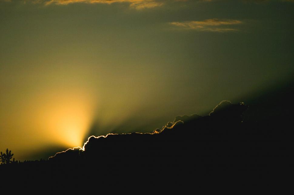 Free Image of Sun Setting Behind Cloud in Sky 
