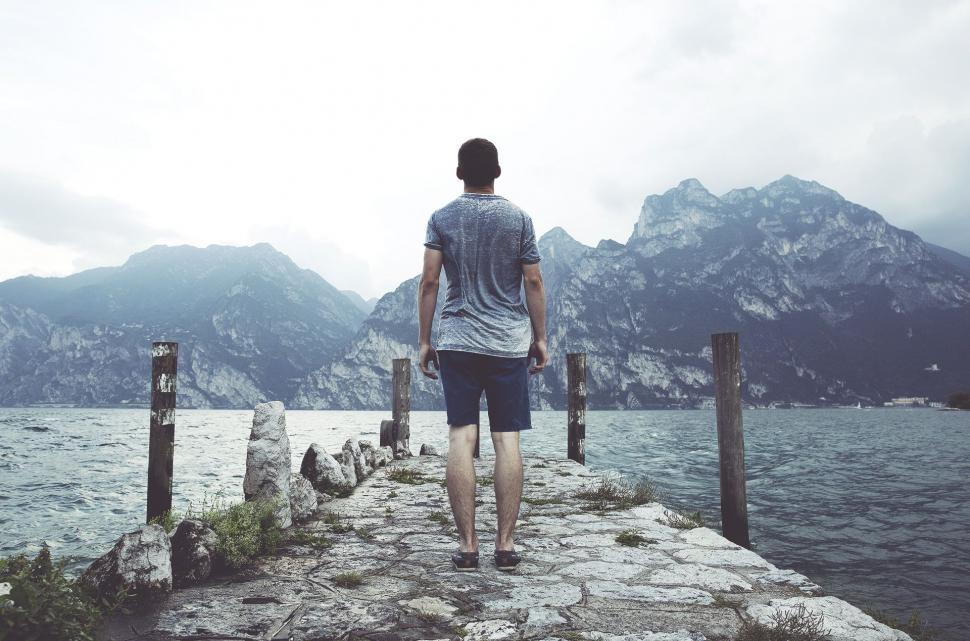Free Image of Man Standing on Pier Looking at Water 