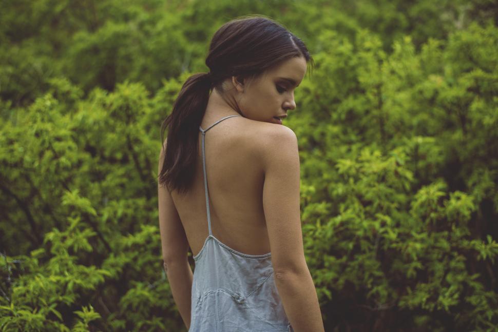 Free Image of Woman Standing in Front of Bush 