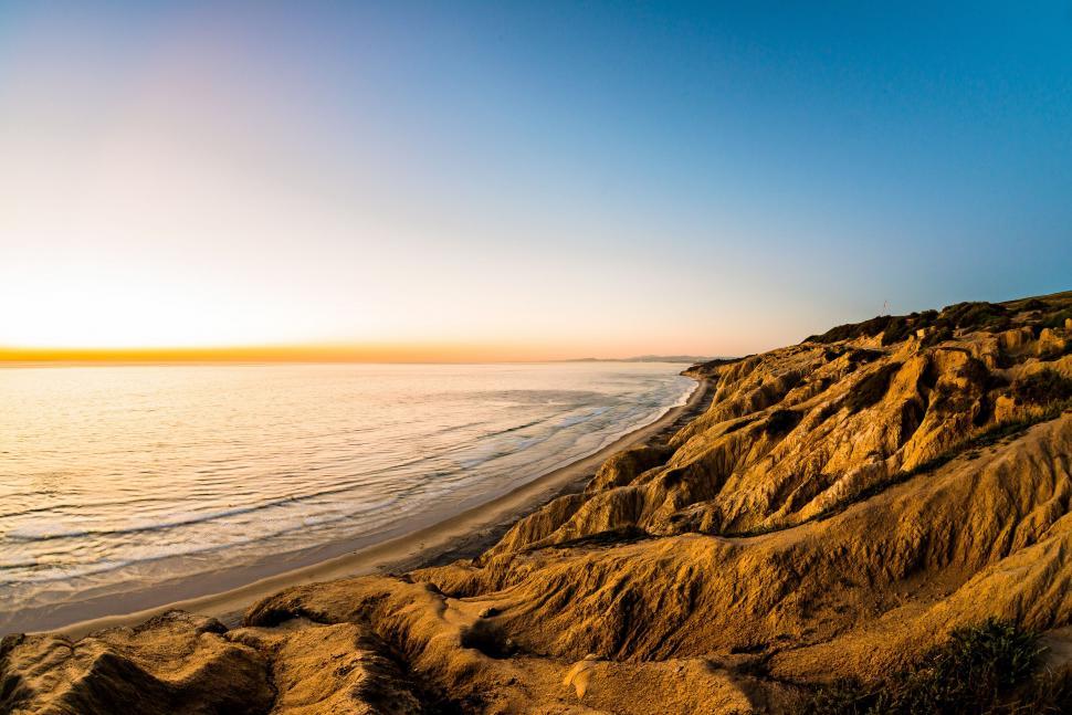 Free Image of Sun Setting Over Water at Beach 