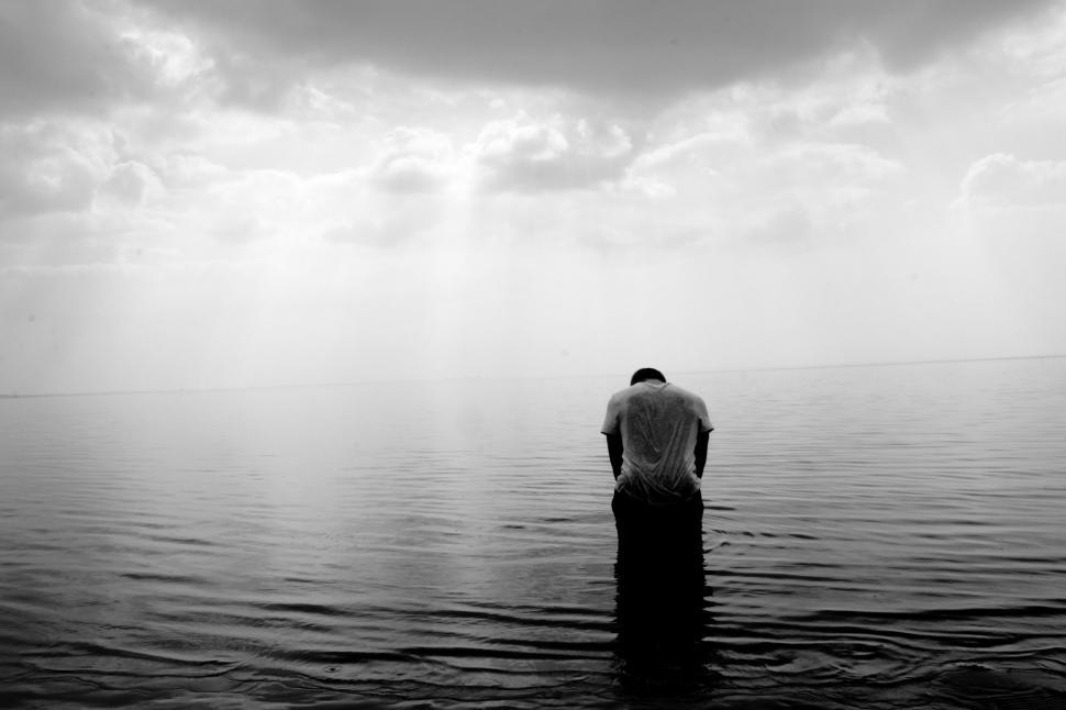 Free Image of Man Standing in the Middle of a Body of Water 