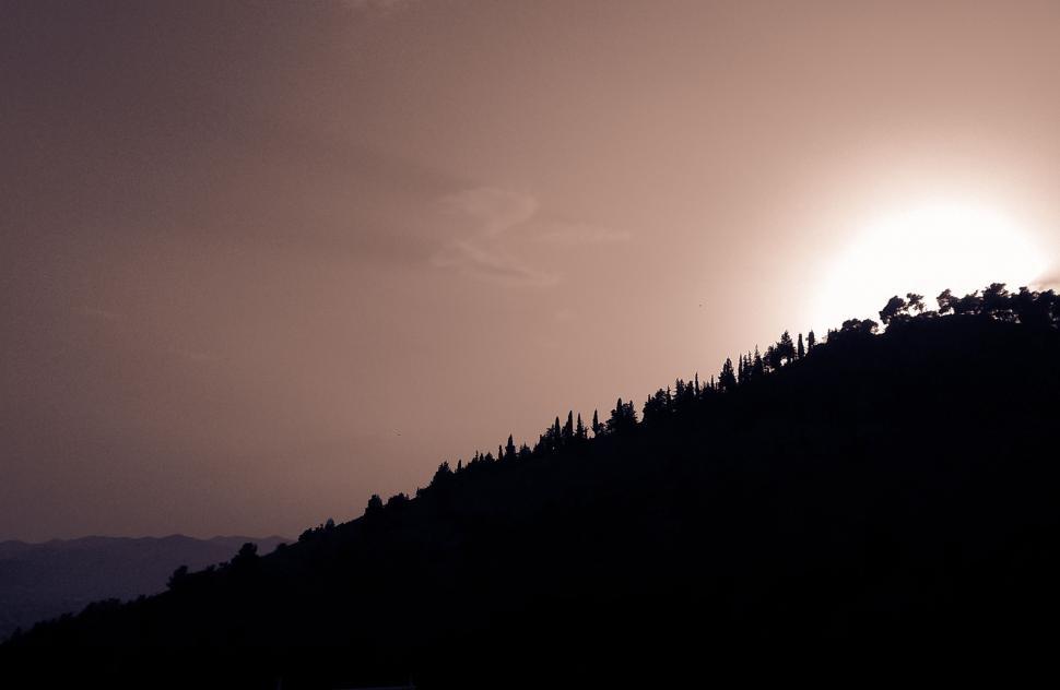 Free Image of Sun Shines Through Clouds Over Mountain 