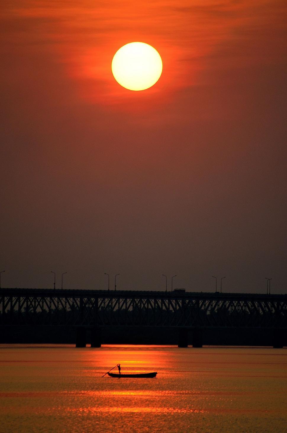 Free Image of Boat Floating on Water Under Sunset 