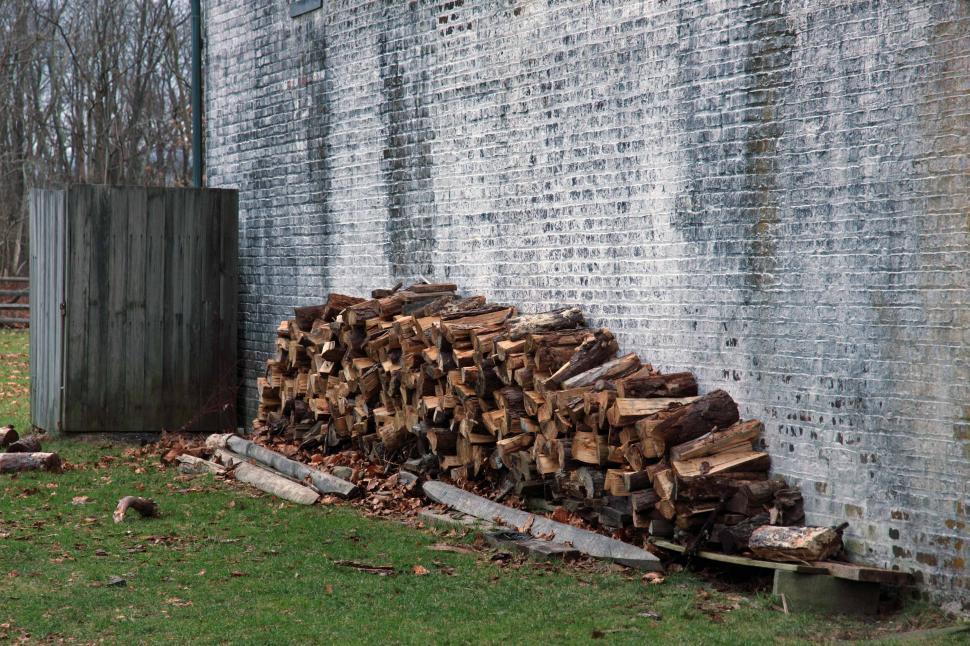 Free Image of Woodpile Against A Brick Wall 