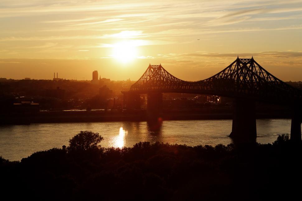 Free Image of Sun Setting Over Bridge on River 