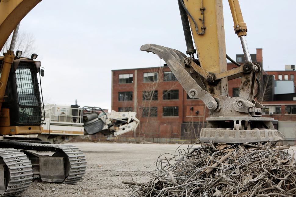 Free Image of Bulldozer Digging Through Pile of Branches 