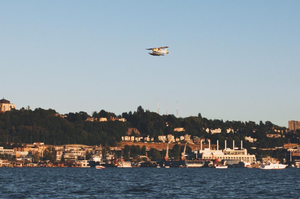 Free Image of Plane Flying Over City on Clear Day 