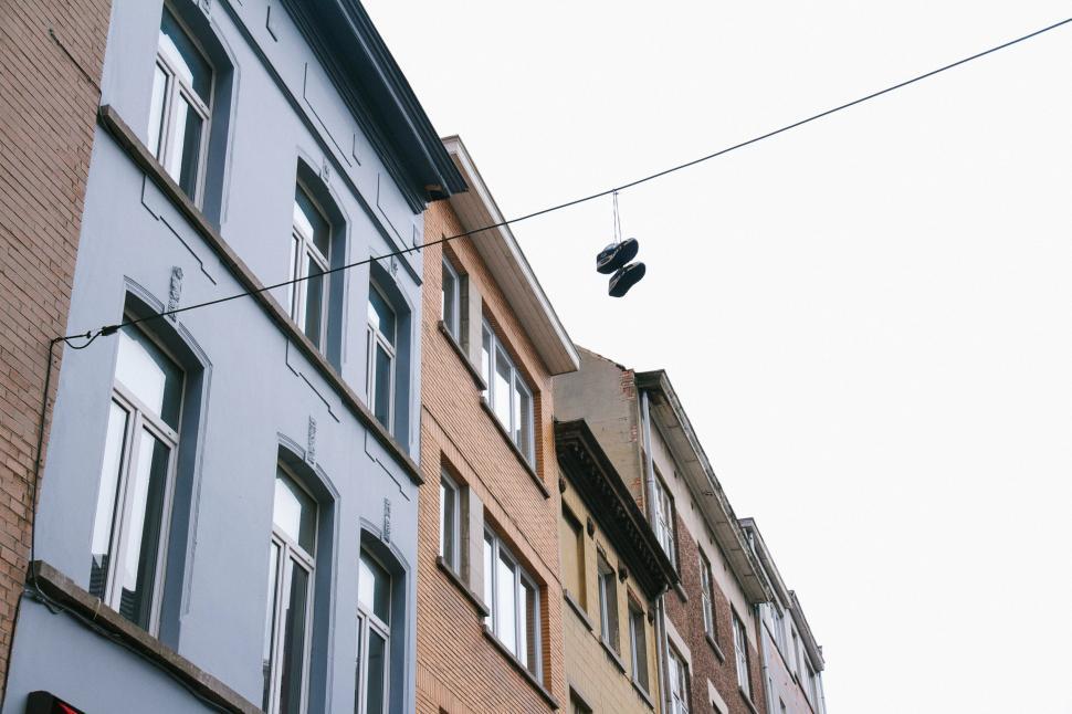Free Image of Bird Perched on Wire in Front of Building 
