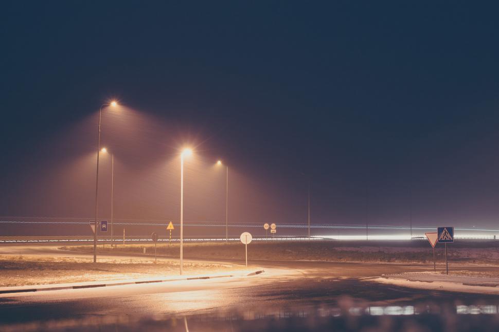 Free Image of Illuminated Street Light Reflecting in Puddle at Night 