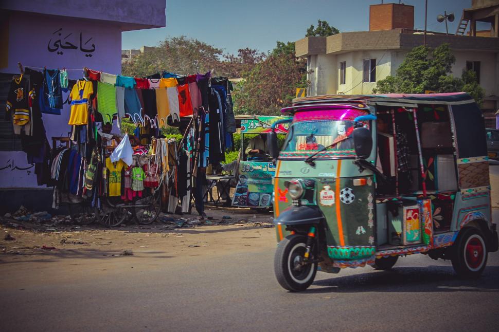 Free Image of Colorful Tuk Tuk Driving Down Street 