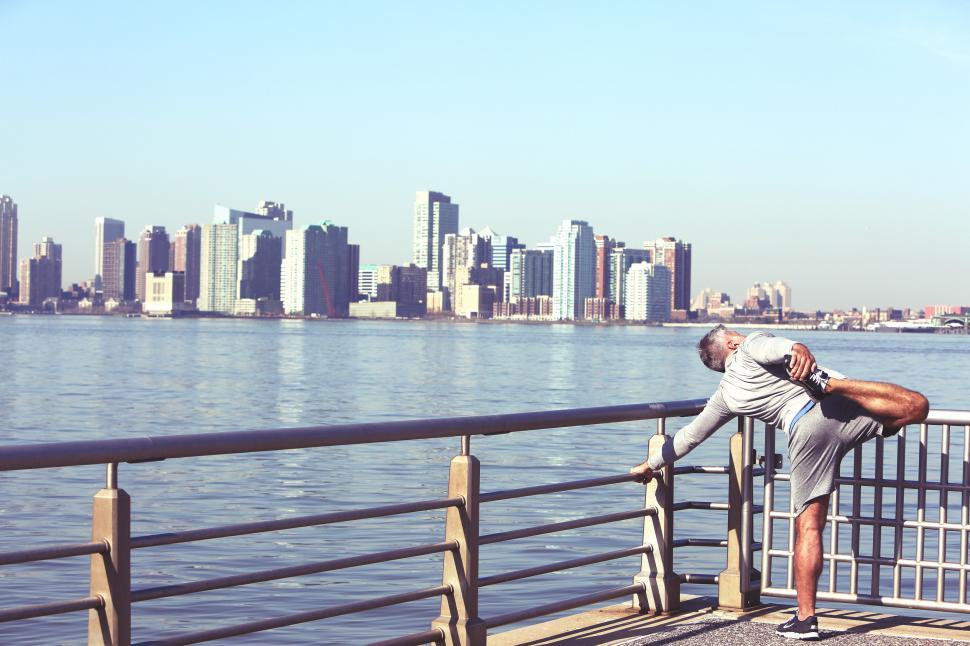 Free Image of Man Leaning on Railing Next to Water 