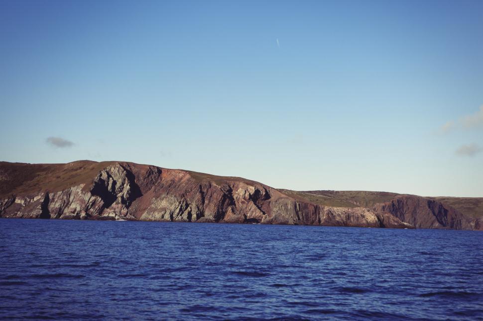 Free Image of Majestic Mountain Rising Above Vast Body of Water 
