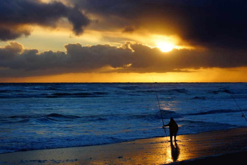 Free Image of Man Standing on Top of Beach Next to Ocean 