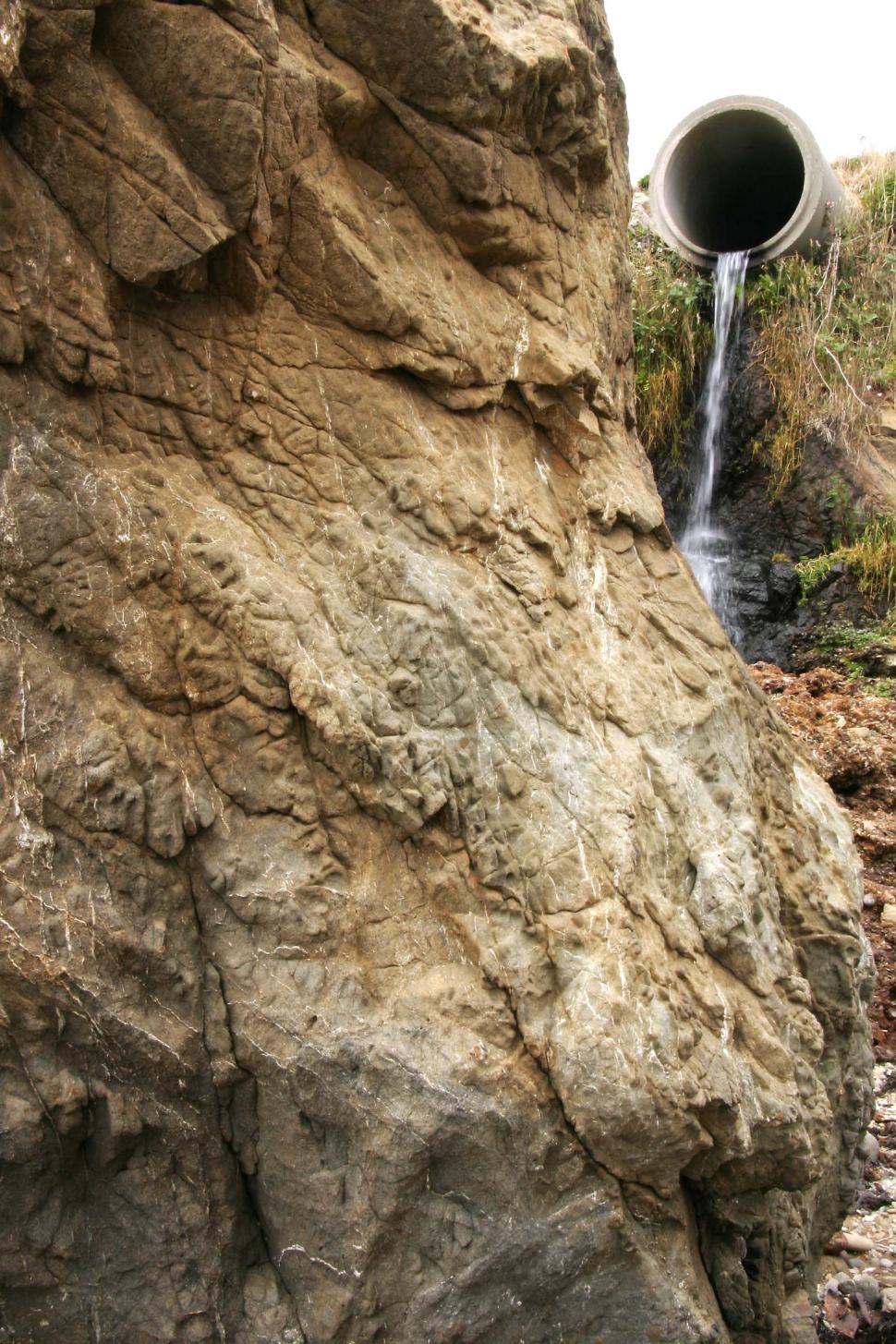 Free Image of Large Pipe Protruding From Side of Mountain 