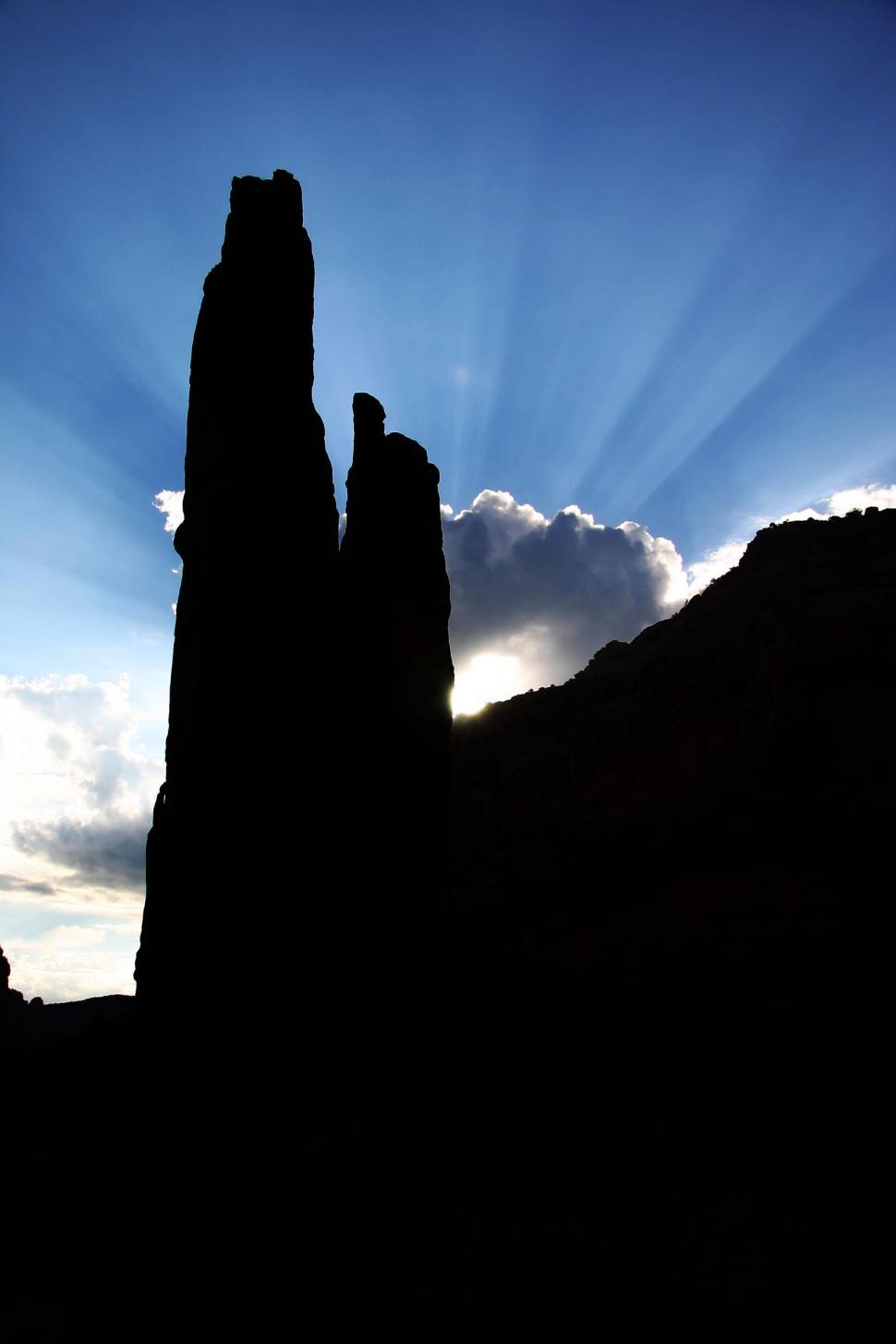 Free Image of Sun Shining Through Clouds Over Mountains 