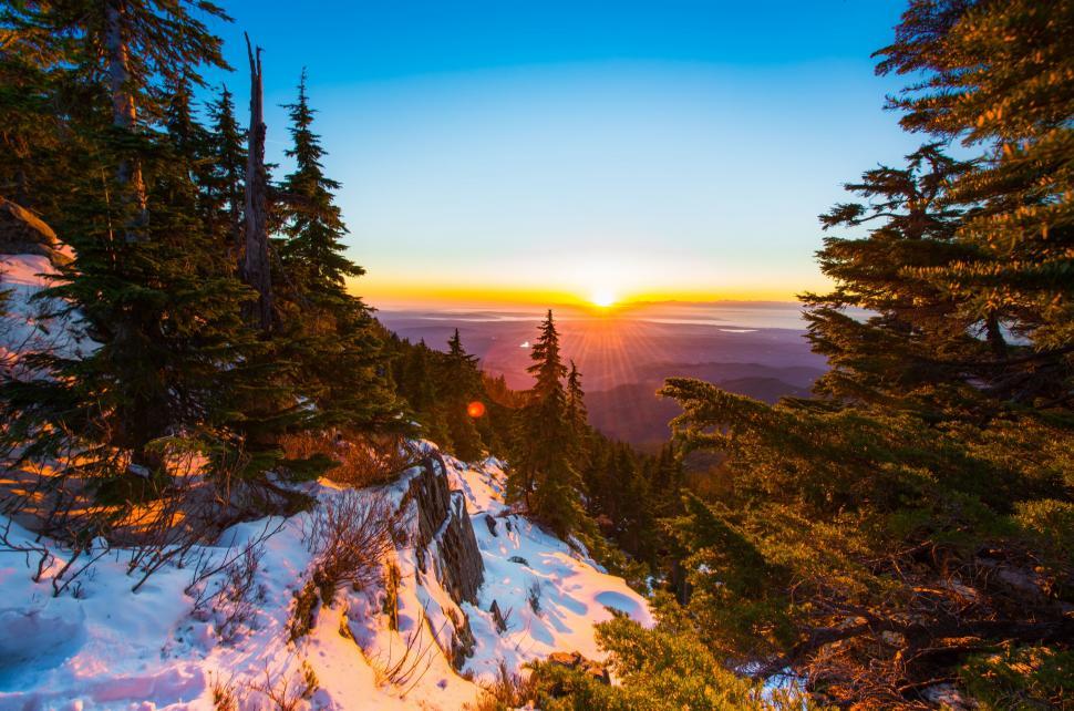 Free Image of Sun Setting Over Snowy Mountain 