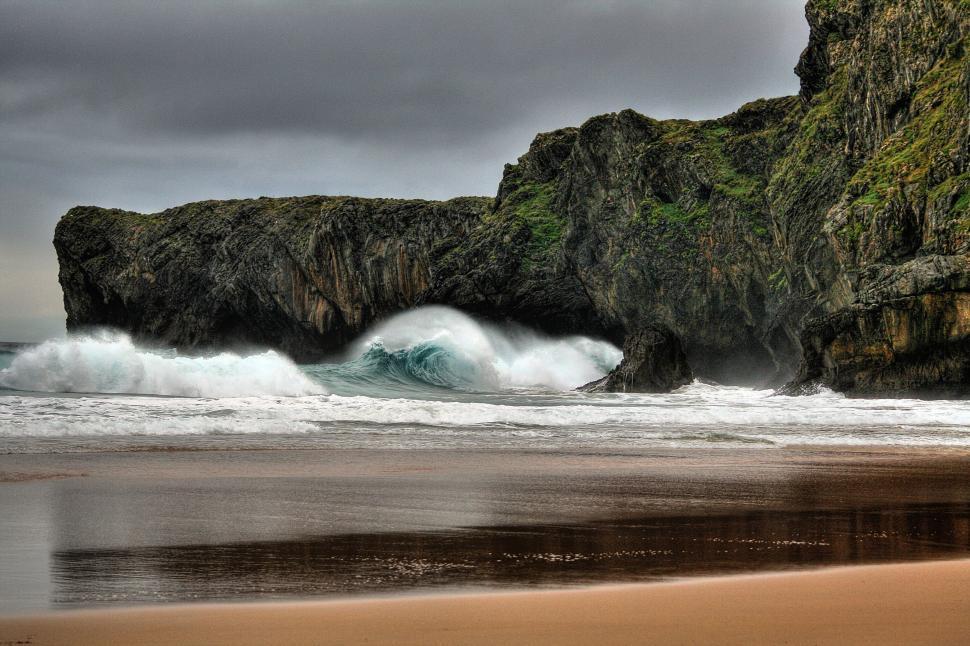 Free Image of Large Rock Protruding From Ocean Near Beach 