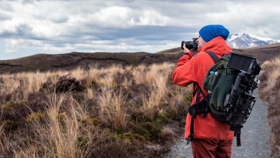 Free Image of Man Capturing Mountain View With Backpack 