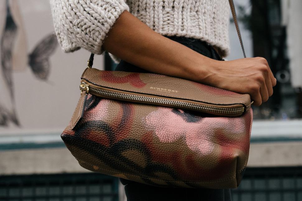 Free Image of Woman Holding Brown Purse With Black and White Design 