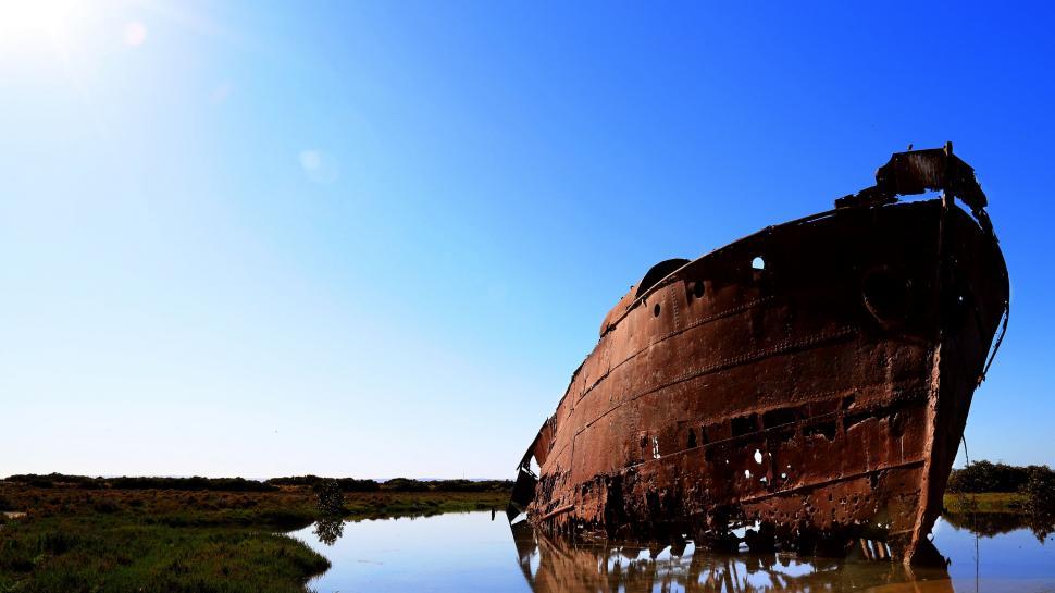 Free Image of Old Boat Floating in Middle of Body of Water 