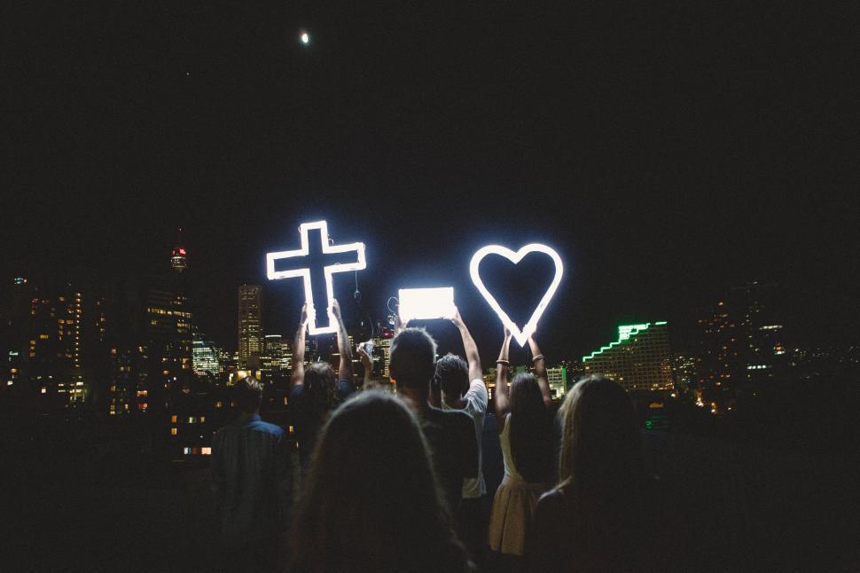 Free Image of Group of People Standing in Front of Night Cityscape 