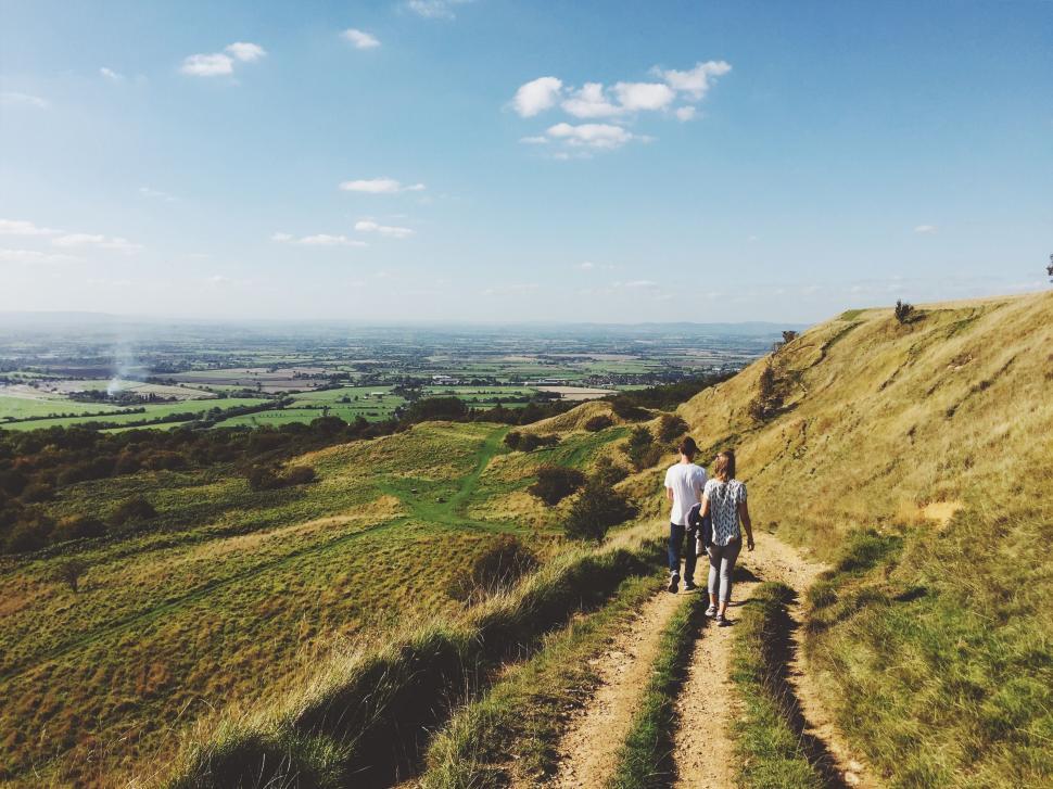 Free Image of Couple Walking Down Dirt Road 