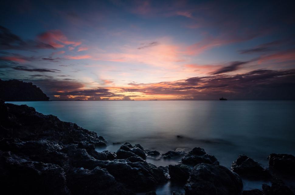 Free Image of Sun Setting Over Ocean and Rocks 