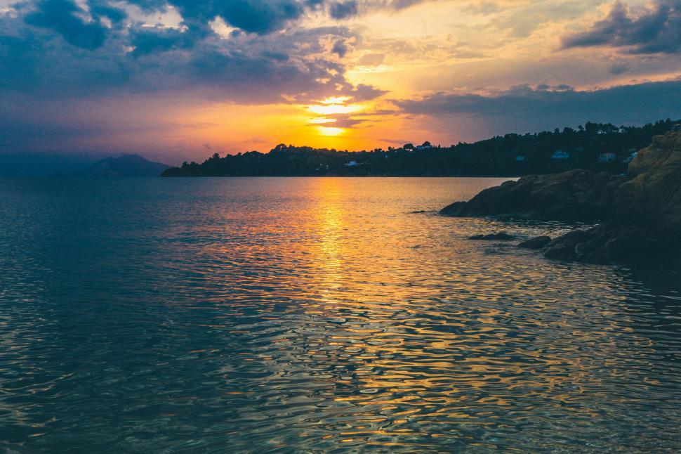 Free Image of Sunset Over a Body of Water With a Small Island 