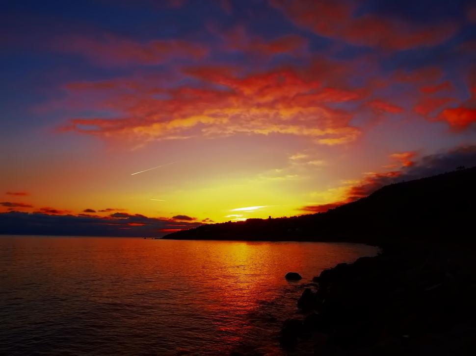 Free Image of Sunset Reflecting on Water With Clouds in Sky 