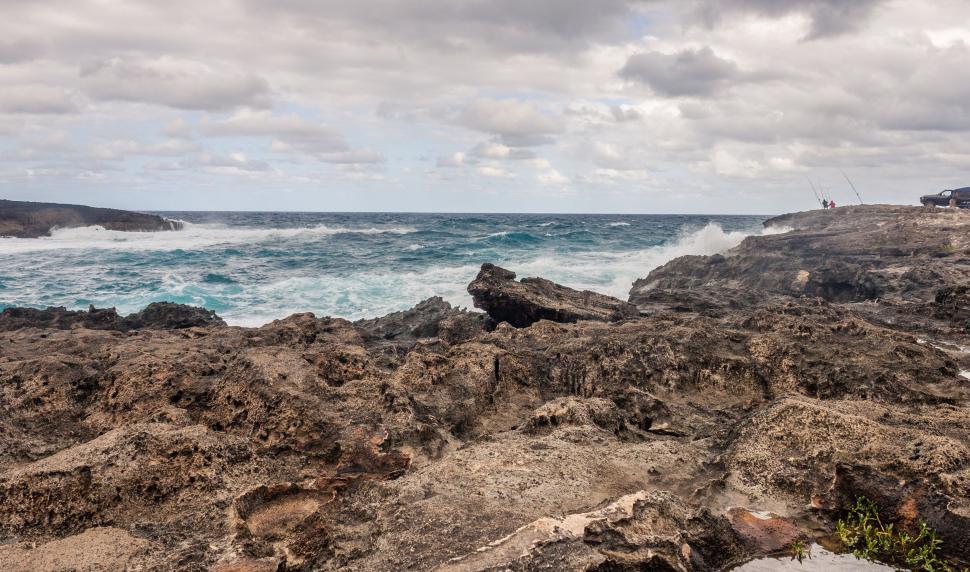 Free Image of Man Standing on Rocky Beach Next to Ocean 