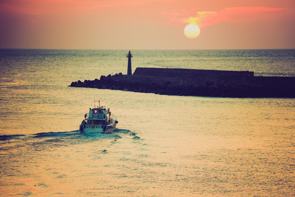 Free Image of Small Boat Sailing Towards Lighthouse 