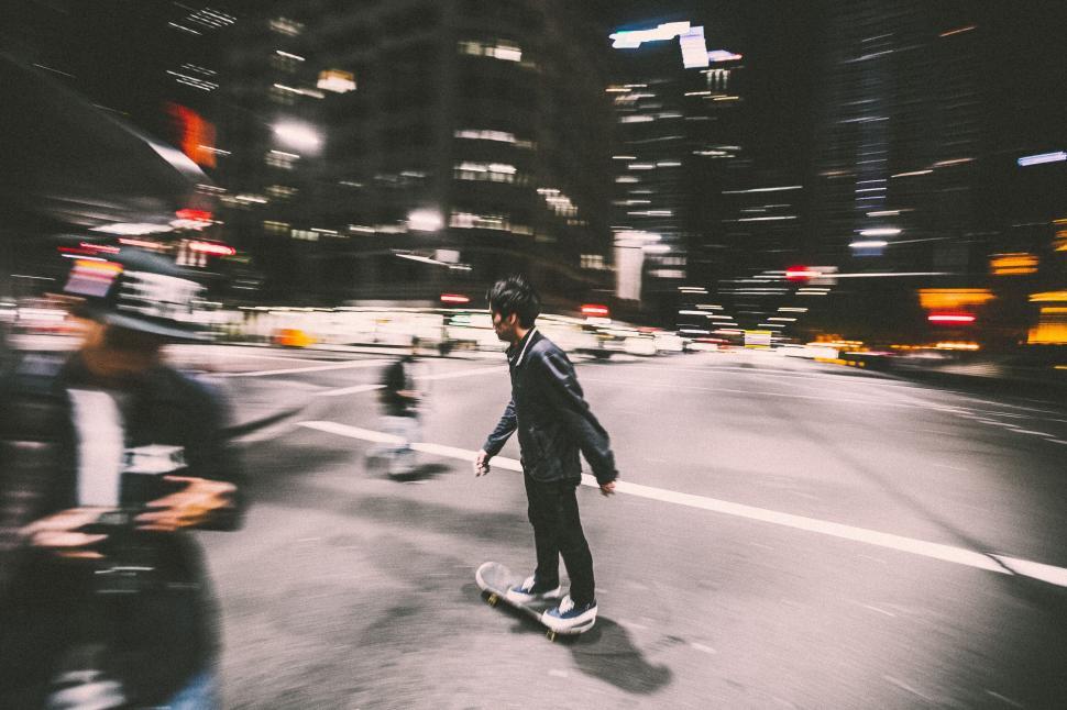 Free Image of Man Skateboarding Down Street at Night 