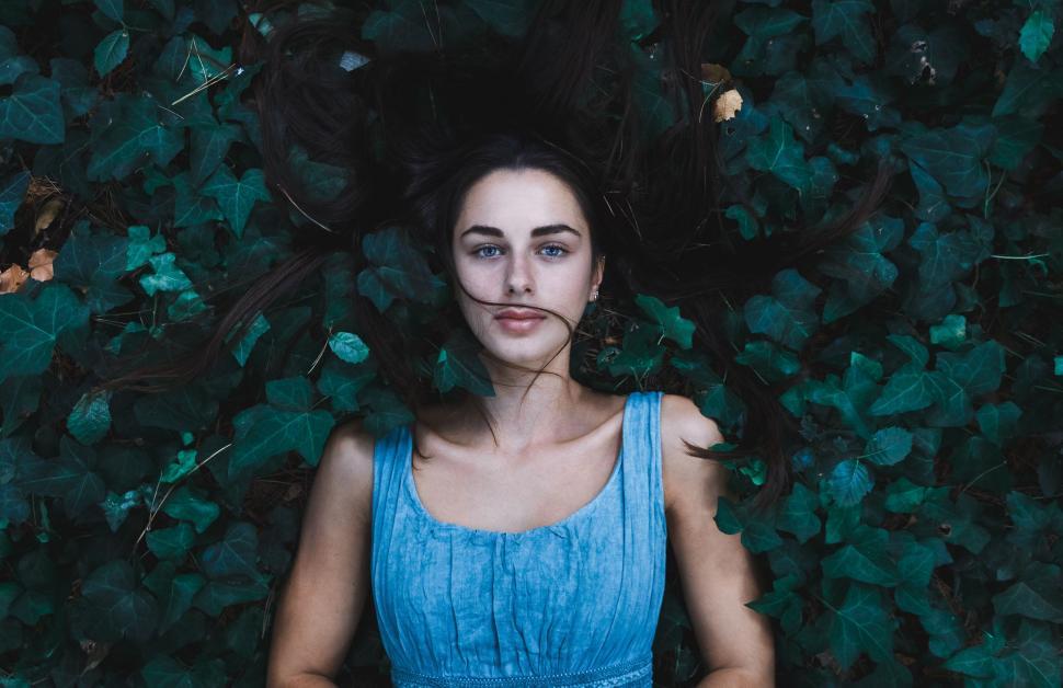 Free Image of Woman in Blue Dress Standing in Front of Bush 