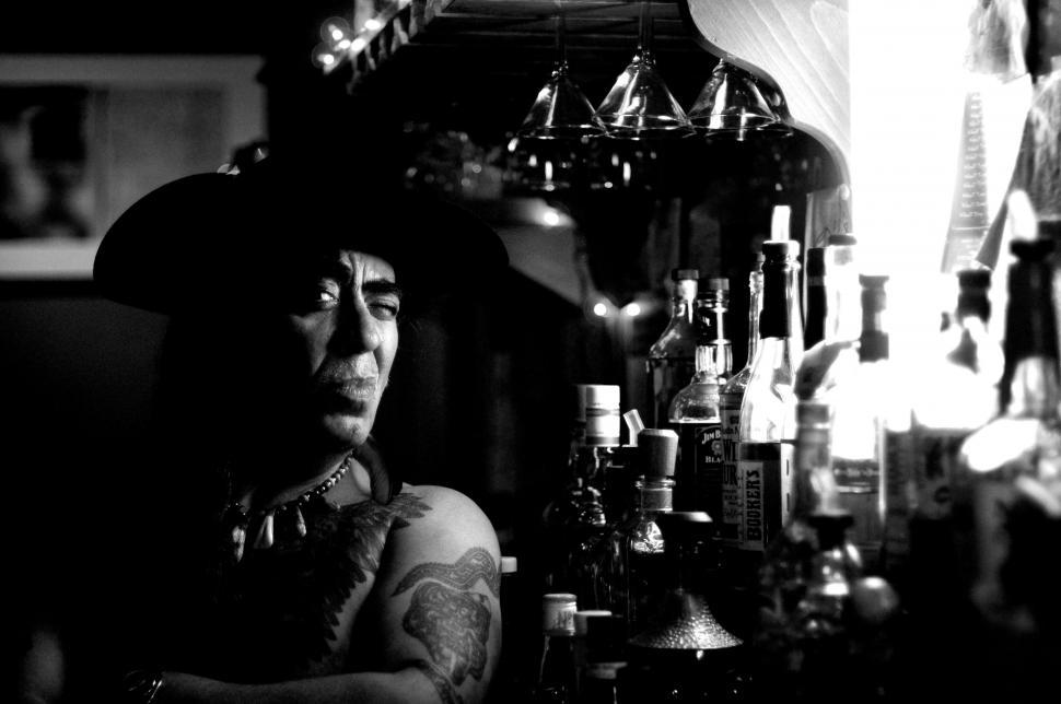 Free Image of Man With Tattoos Sitting at a Bar 