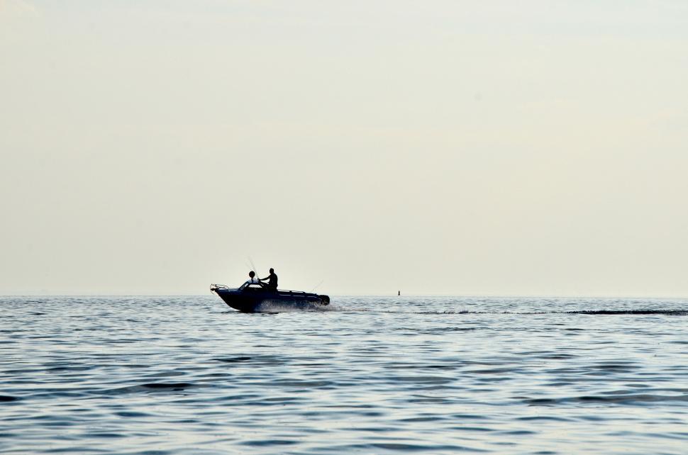 Free Image of Small Boat Floating in Vast Water 