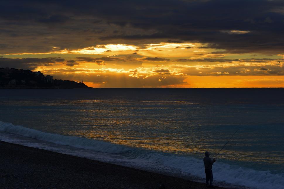 Free Image of Person Standing on Beach at Sunset 