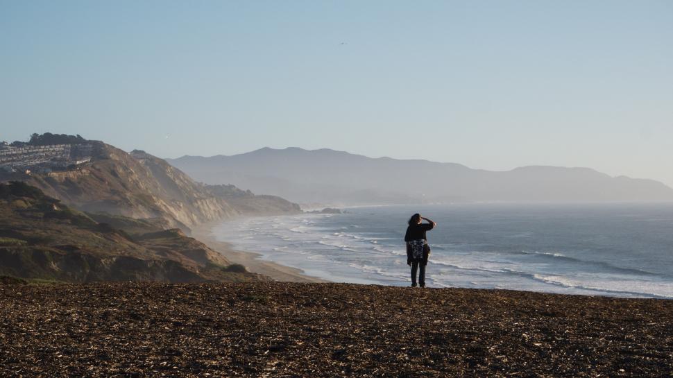Free Image of Person Standing on Beach Next to Ocean 