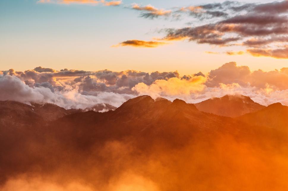 Free Image of Plane Flying Over Mountain Covered in Clouds 