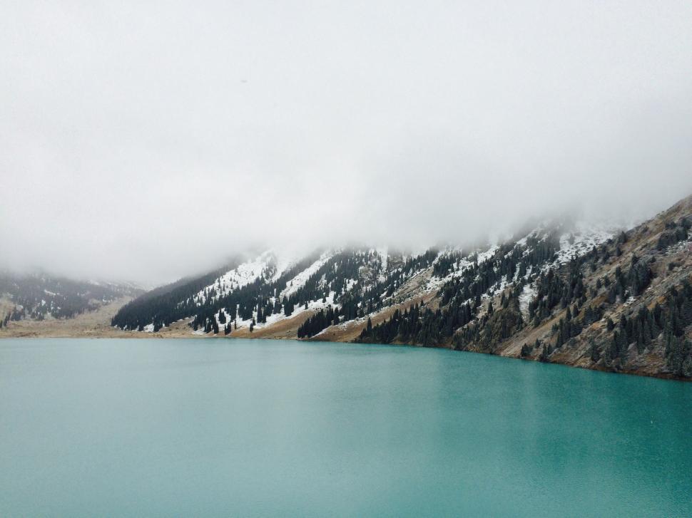 Free Image of Snow-Covered Mountains Surrounding Large Body of Water 