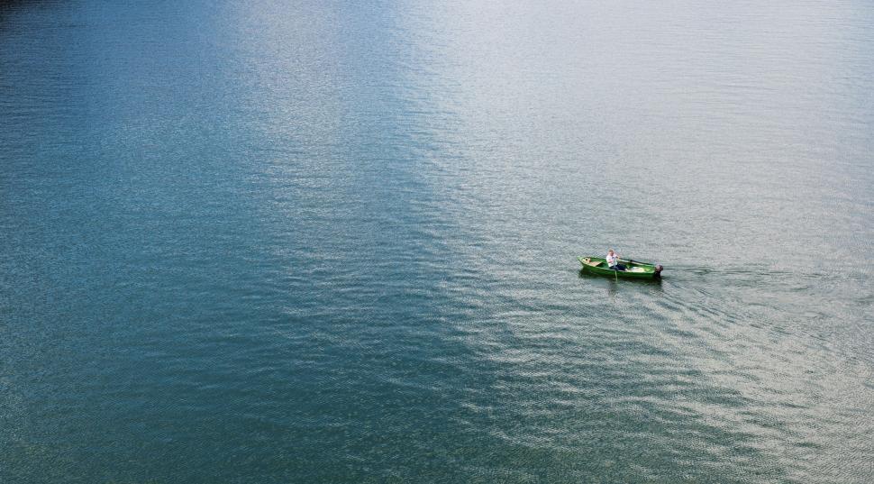 Free Image of Small Boat Sailing on Vast Ocean Waters 