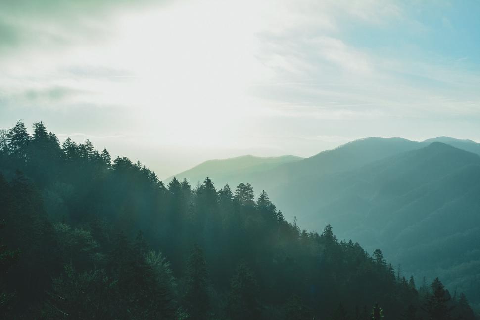 Free Image of Sun Shines Through Clouds Over Mountains 