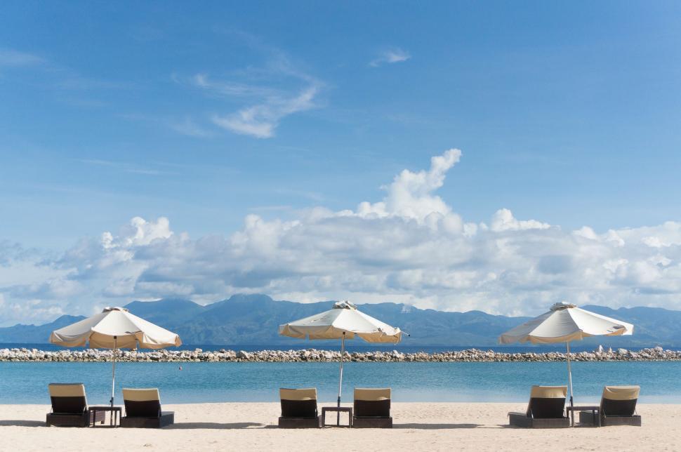 Free Image of Row of Lawn Chairs on Sandy Beach 