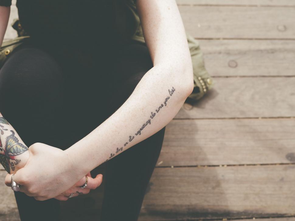 Free Image of Woman With Tattoo Holding Skateboard 