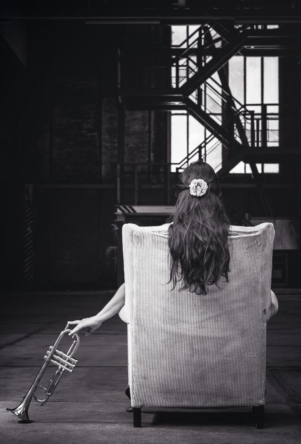 Free Image of Woman Sitting in Chair With Trumpet 