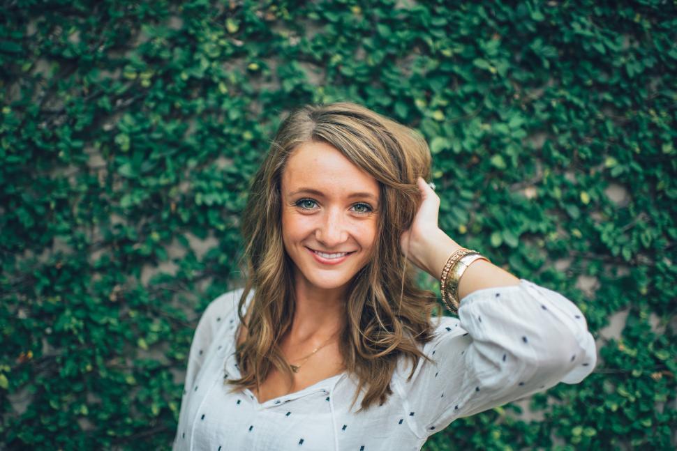 Free Image of Woman Standing in Front of Green Wall 
