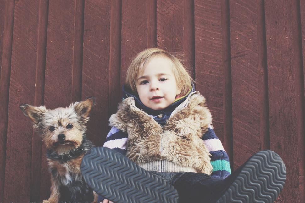Free Image of Little Girl Sitting on Ground With Dog 
