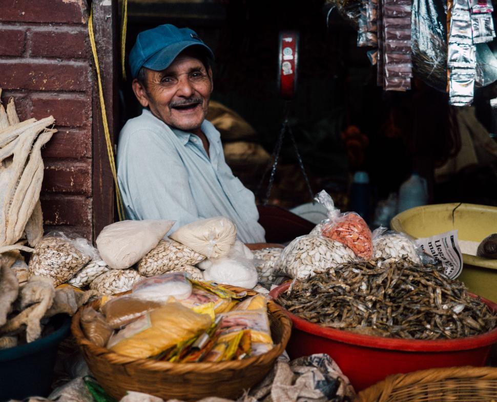 Free Image of Man Sitting in Front of a Pile of Food 