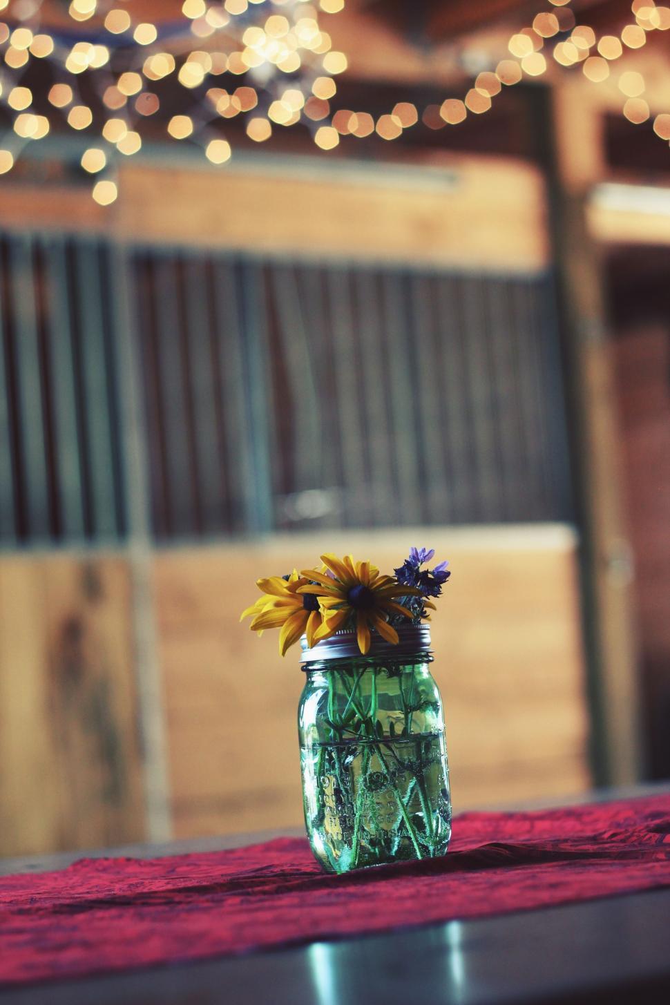 Free Image of Mason Jar Filled With Yellow Flowers on Table 